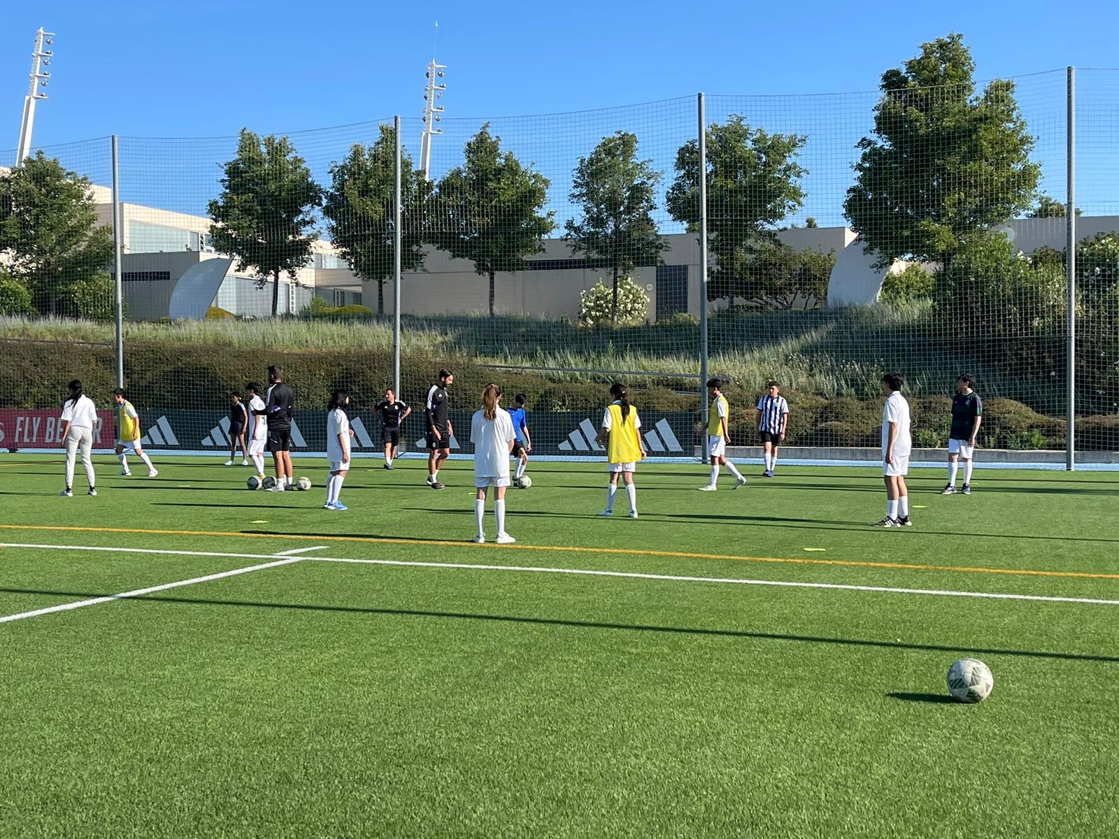 Chicos, chicas, jóvenes y niños jugando con entrenadores de la cantera del Real Madrid